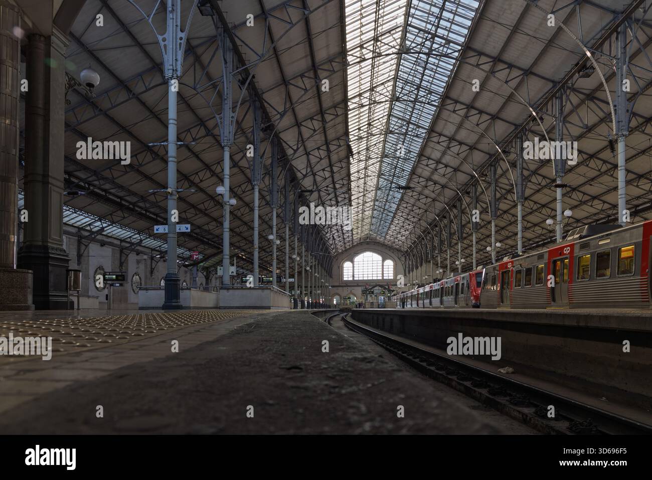 L'intérieur spectaculaire et incliné de la gare Rossio à Lisbonne, au Portugal, avec son toit historique en fer et en verre et un train de banlieue en attente. Banque D'Images