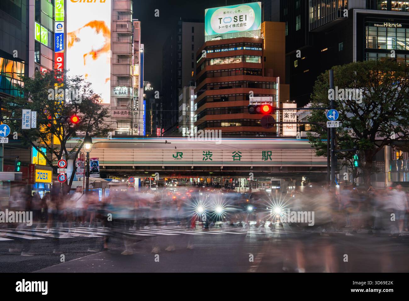 La foule nocturne traverse Shibuya Scramble par le panneau JR Shibuya Station Banque D'Images
