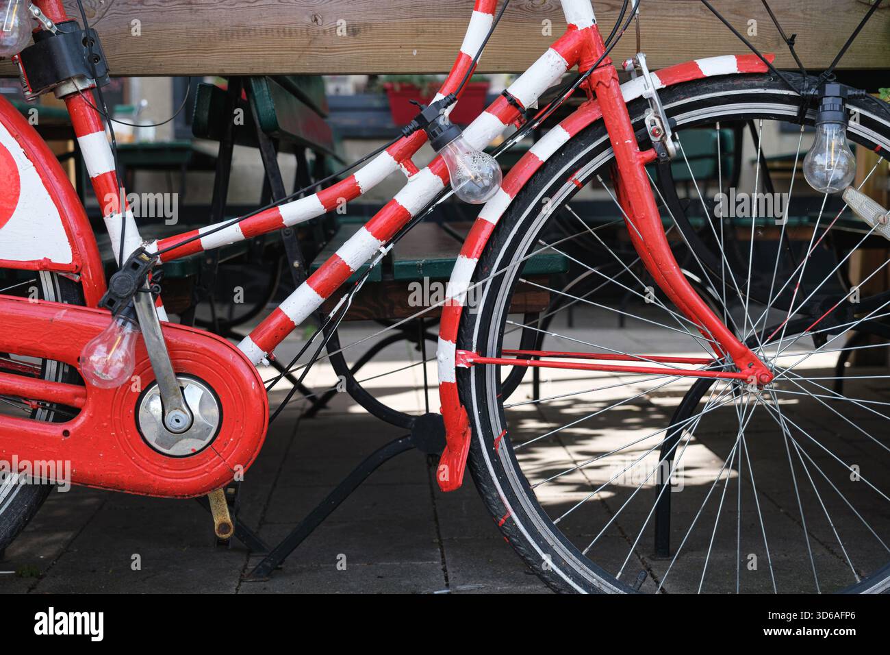 Vue rapprochée du vélo décoratif rouge et blanc avec des lumières dans un cadre de café confortable Banque D'Images