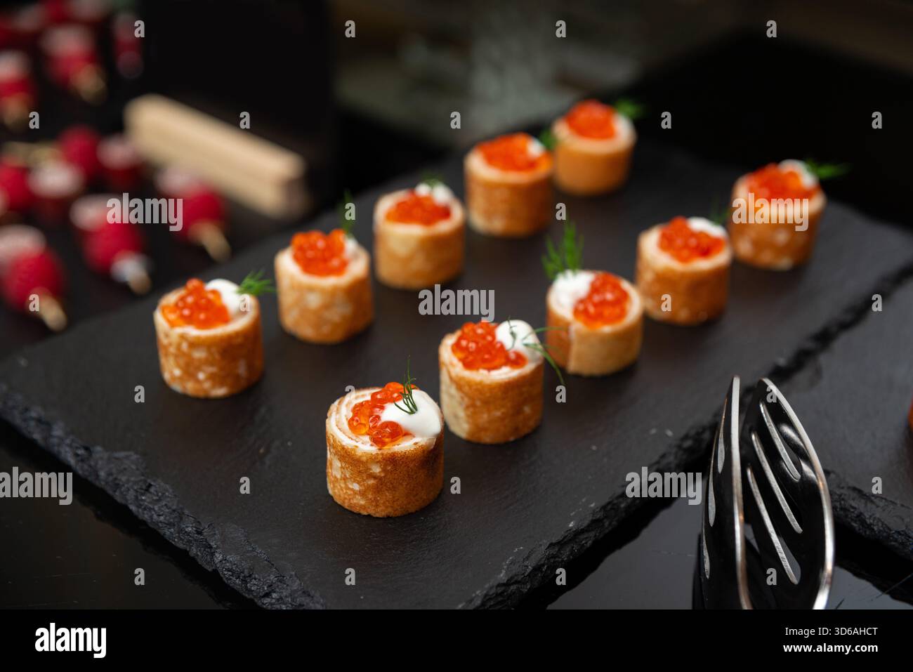 Une sélection de hors-d'œuvre gastronomique magnifiquement arrangée avec œufs de saumon sur un plateau d'ardoise. cette présentation élégante met en valeur une cuisine raffinée Banque D'Images