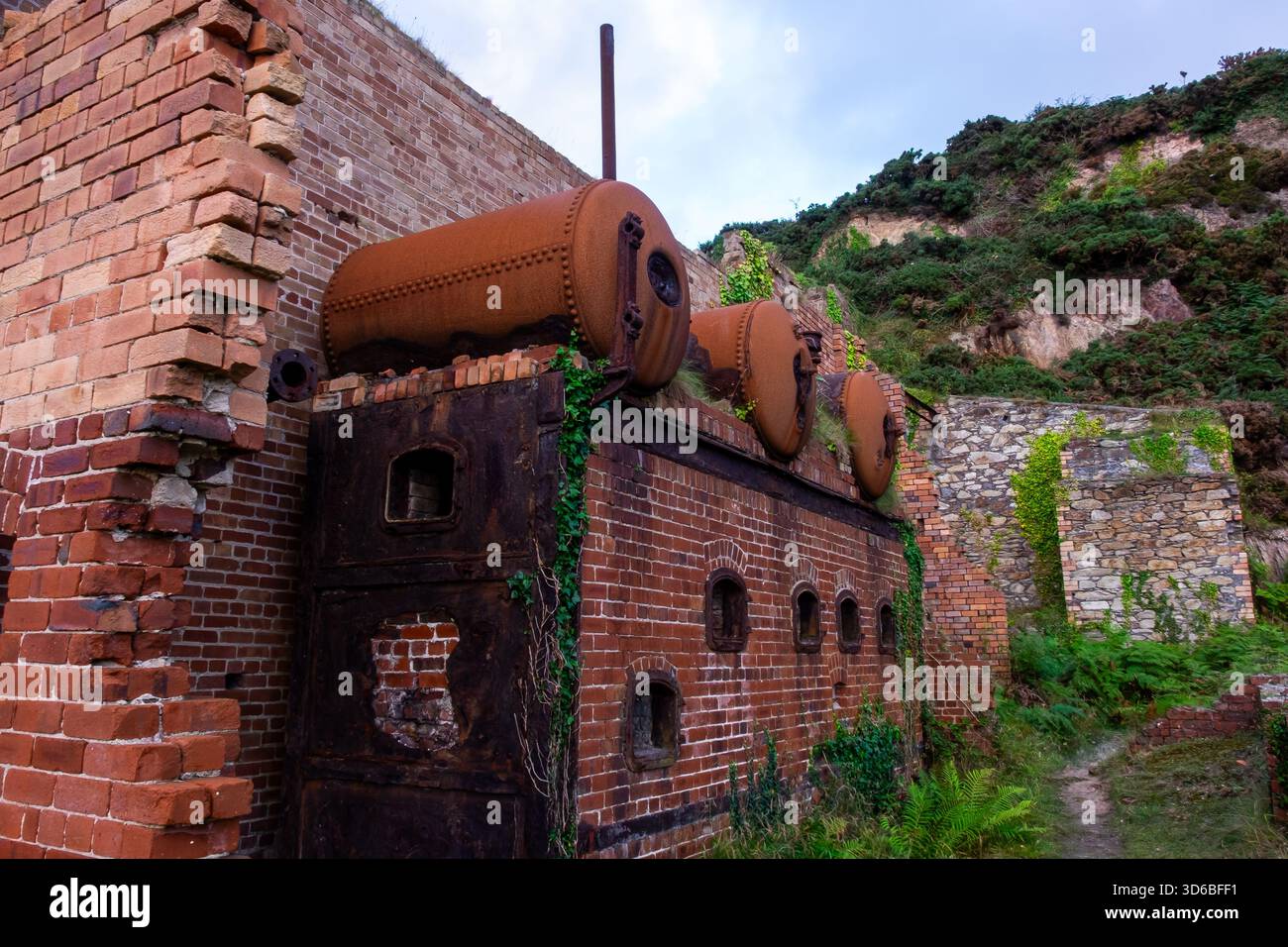 Maçonnerie de Porth Wen abandonnée avec des structures envahies par la végétation Banque D'Images