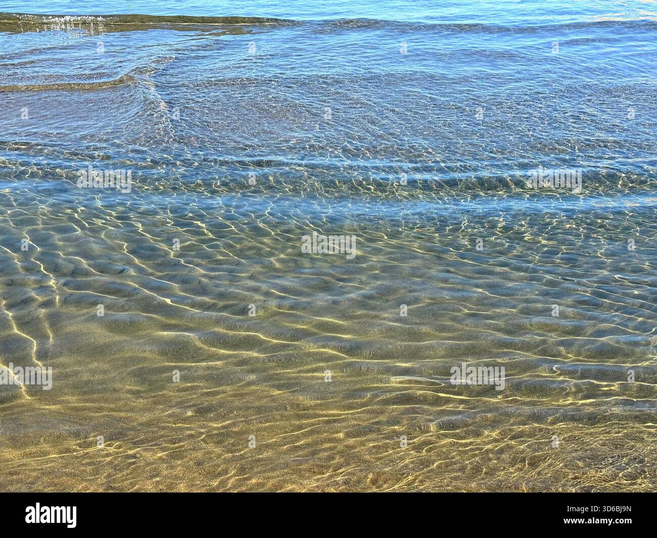Eau claire sur la plage de sable Banque D'Images