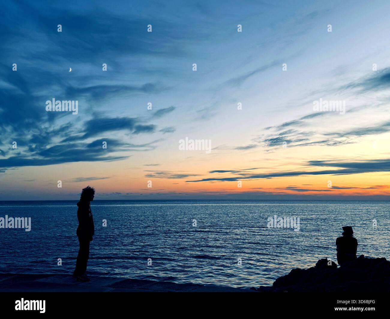 Jeunes gens sur le rivage de la mer la nuit Banque D'Images