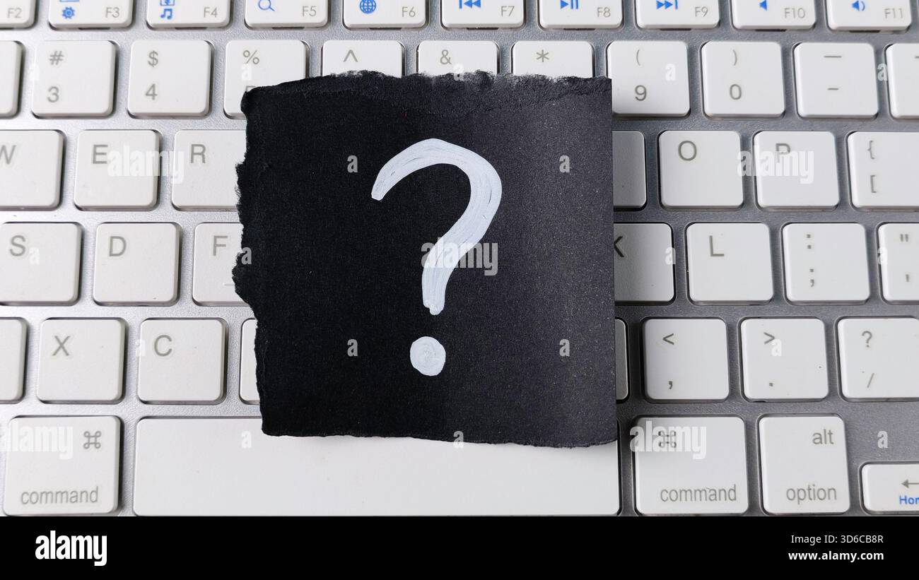 Question numérique et concept d'aide en ligne avec point d'interrogation sur papier noir centré sur clavier d'ordinateur moderne Banque D'Images