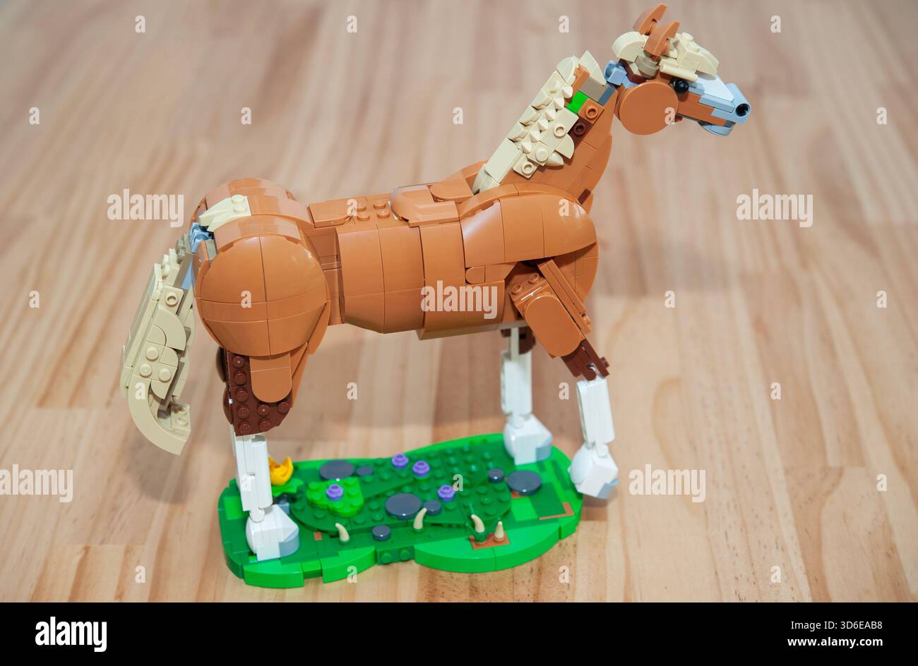 Modèle de cheval LEGO photographié d'en haut sur une surface en bois, présentant une construction en briques détaillée Banque D'Images