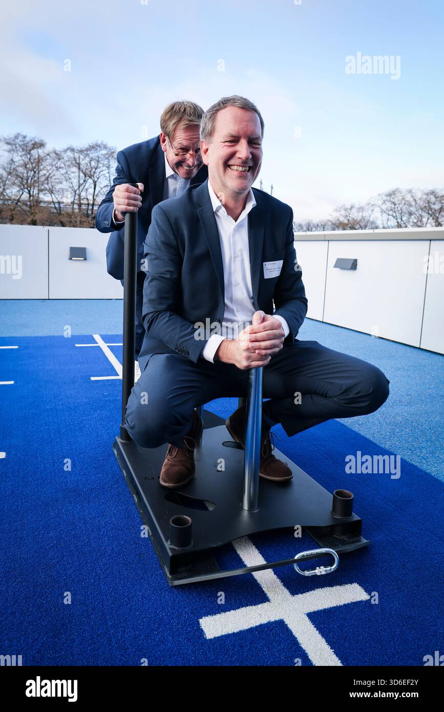 20 novembre 2025, Hambourg : Christian Gerloff (à gauche), directeur médical et président du conseil d'administration du Centre médical universitaire Hamburg-Eppendorf (UKE), pousse Götz Welsch, directeur médical de l'Athleticum et médecin-chef de l'équipe Hamburger SV, sur un traîneau à l'ouverture de l'Athleticum am Volkspark. Après des années de travaux de planification et de construction, l’Athleticum am Volkspark a été officiellement inauguré jeudi. Le nouveau centre offre environ 5 000 mètres carrés de diagnostic, de thérapie, de réadaptation et de prévention à la pointe de la technologie pour les athlètes professionnels et récréatifs. Photo : Christian Chari Banque D'Images