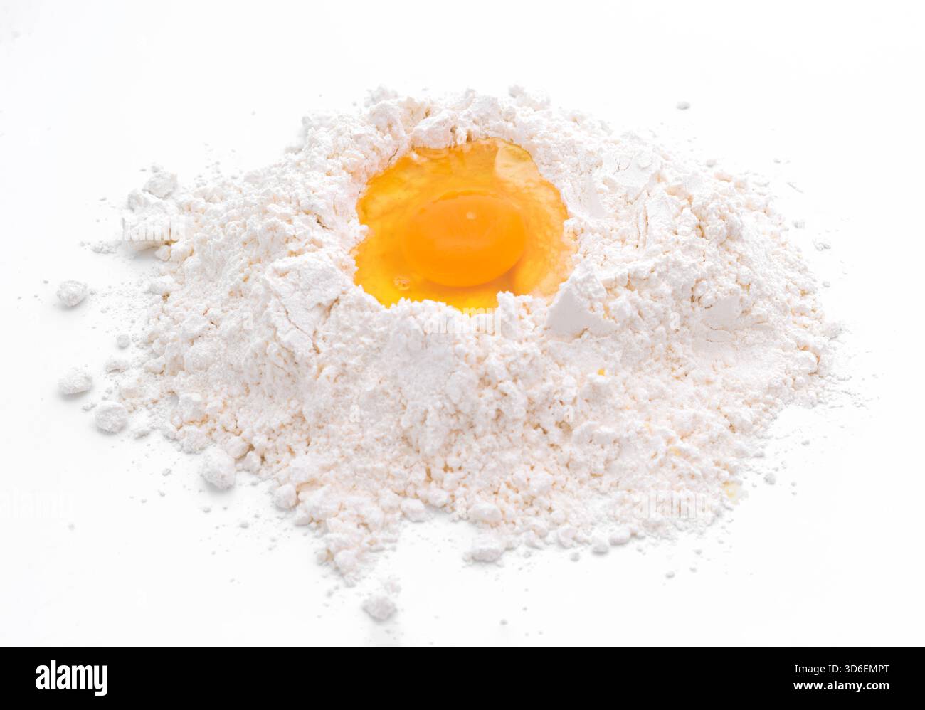 Une vue aérienne d'un œuf cru niché dans un monticule de farine blanche, sur fond blanc épuré et minimaliste, capturant l'essentiel de la cuisson Banque D'Images
