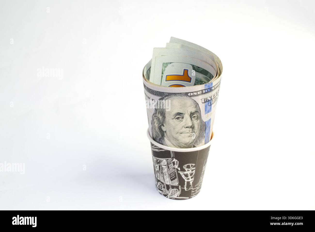 Basra, Irak - 5 août 2025 : une tasse de papier enveloppée et remplie de cent dollars Banque D'Images