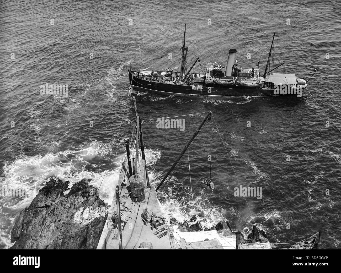 Un tournant du XIXe/XXe siècle construction du phare de Fastnet. La construction a commencé en 1897 avec le nivellement du site, et les premiers des 2 047 blocs à queue d'aronde de granit de Cornouailles ont été posés en juin 1899. Le 'Ierne', un petit bateau à vapeur (photo), a été spécialement construit pour transporter les blocs vers l'île. Le nouveau phare est entré en service le 27 juin 1904, après avoir coûté près de £90,000. Banque D'Images