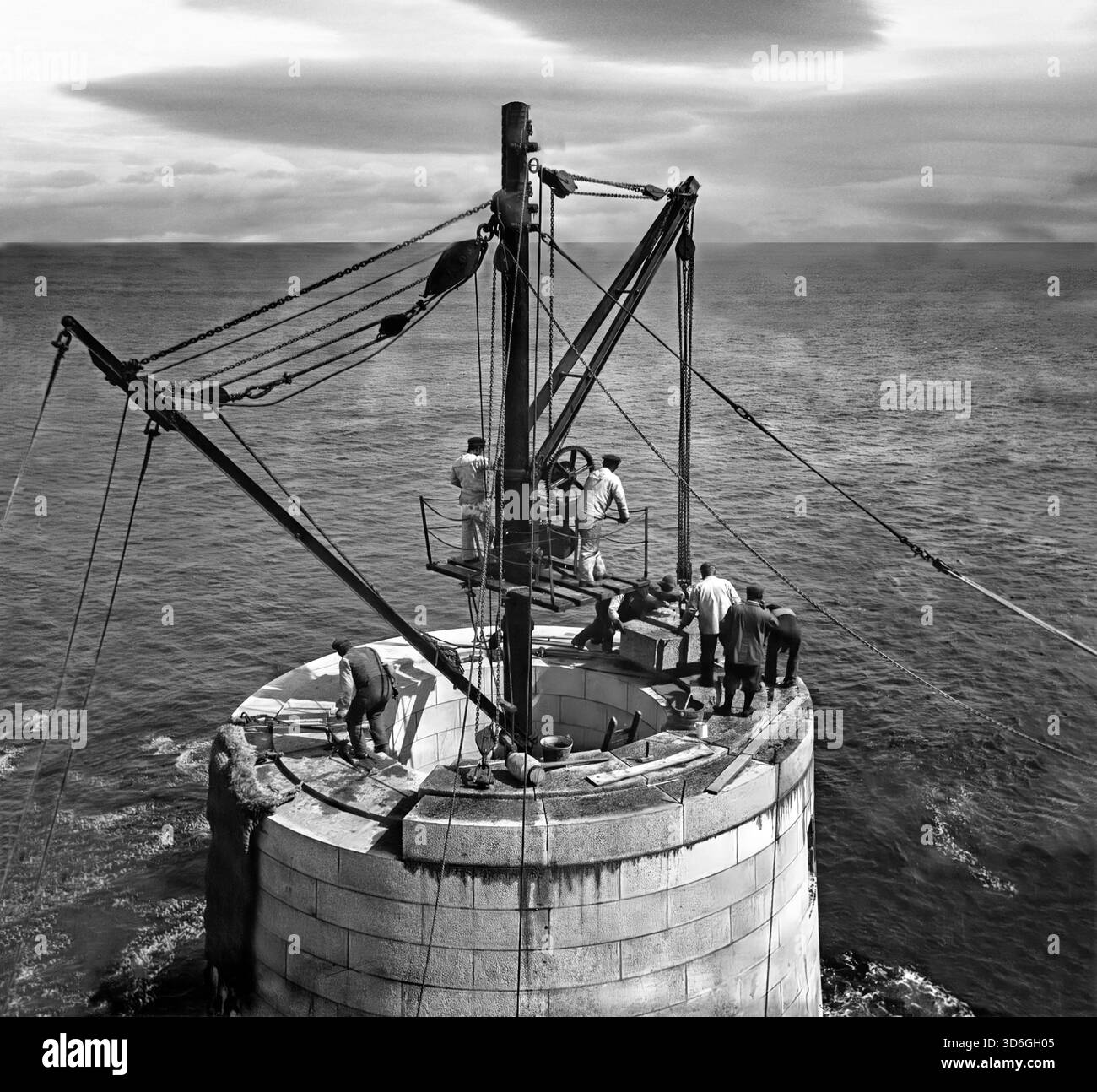 Un tournant du XIXe/XXe siècle construction du phare de Fastnet. La construction a commencé en 1897 avec le nivellement du site, et les premiers des 2 047 blocs à queue d'aronde de granit de Cornouailles ont été posés en juin 1899. Le 'Ierne', un petit bateau à vapeur a été spécialement construit pour transporter les blocs vers l'île. Le nouveau phare est entré en service le 27 juin 1904, après avoir coûté près de £90,000. Banque D'Images