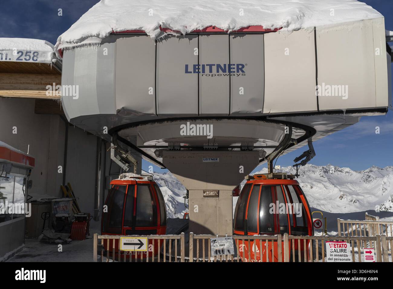 Ponte di Legno, Italie - 03.12.2023 : Station de télécabine avec cabines enneigées dans la station de ski, paysage alpin montagneux d'hiver. Gondoles prêtes au tra Banque D'Images