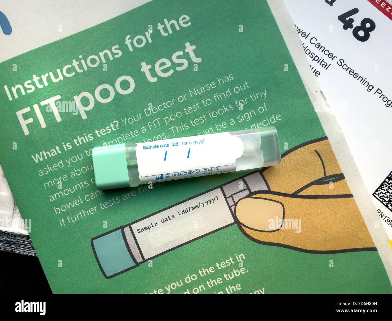Gros plan d'un kit de test D'AJUSTEMENT sur une notice d'information pour le dépistage du cancer de l'intestin avec texte d'instruction visible du UK NHS Banque D'Images