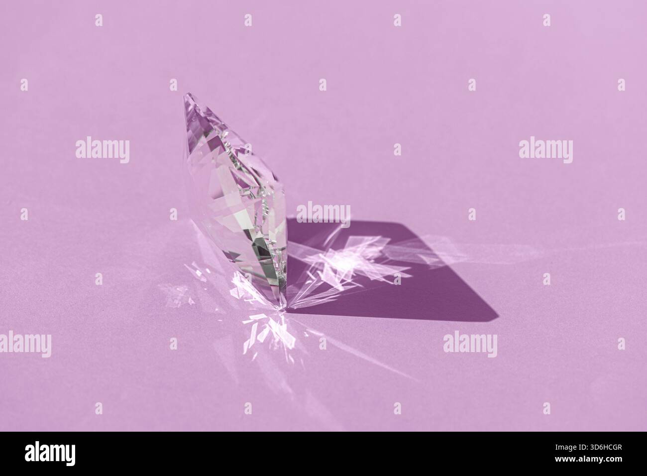 Prisme en cristal avec diffraction de lumière des couleurs du spectre et réflexion avec lumière tendance et ombres dures sur fond rose. Réflecteur de spectre lumineux Banque D'Images