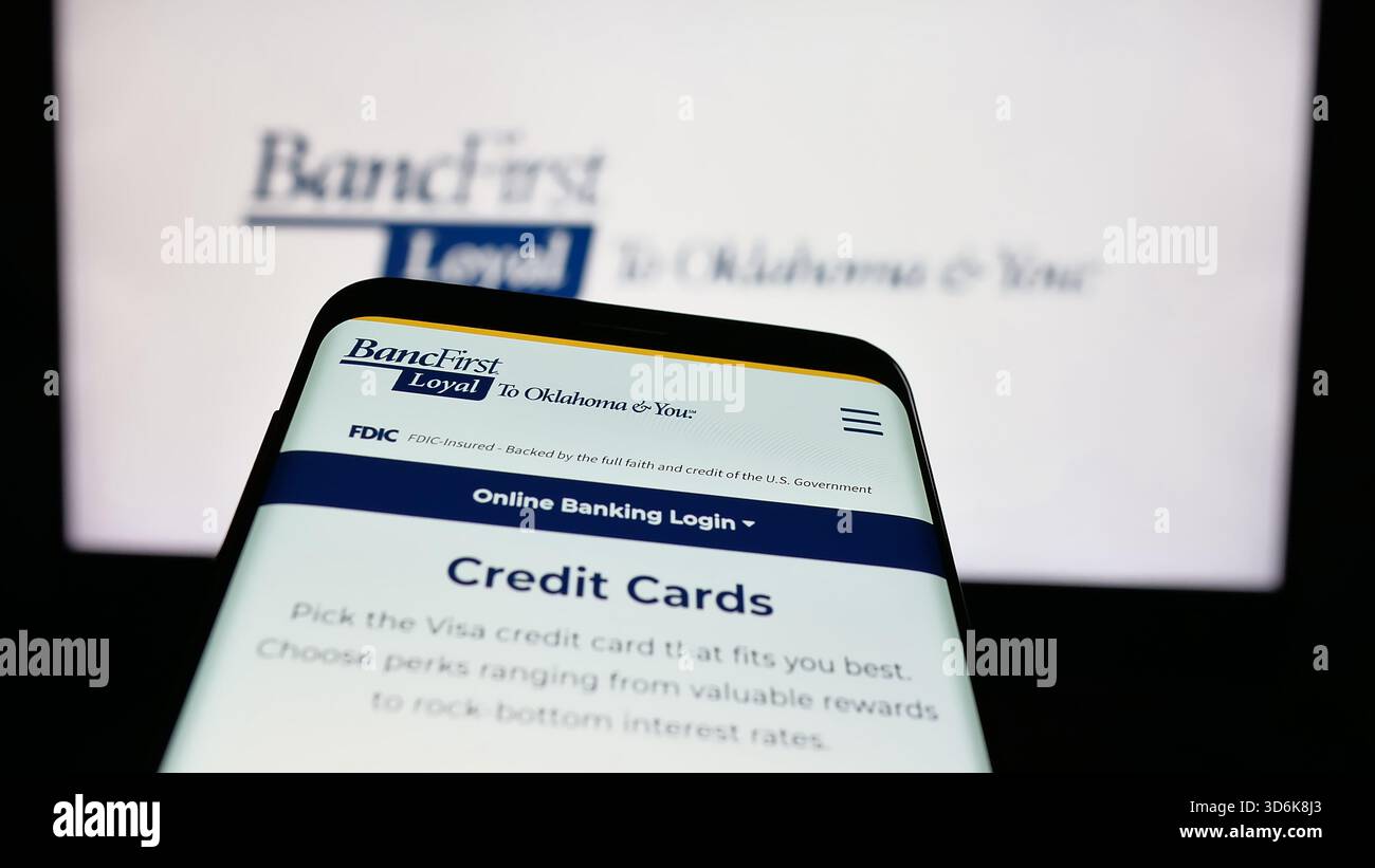 Stuttgart, Allemagne - 11-12-2025 : téléphone portable avec le site Web de la société financière américaine BancFirst Corporation sur l'écran devant le logo. Banque D'Images