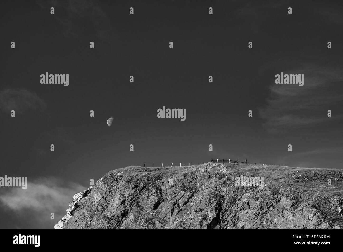 Falaise côtière noire et blanche avec la lune au-dessus Banque D'Images