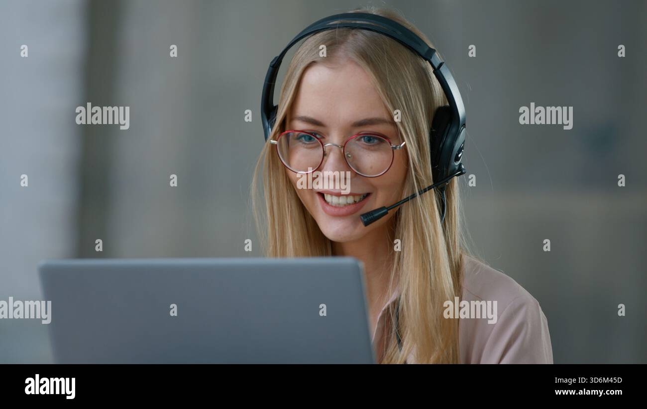 Femme d'affaires caucasienne dans le casque parlant appel vidéo avec ordinateur portable dans le bureau fille femme d'affaires Helpline agent agent de service à la clientèle centre d'appel Banque D'Images