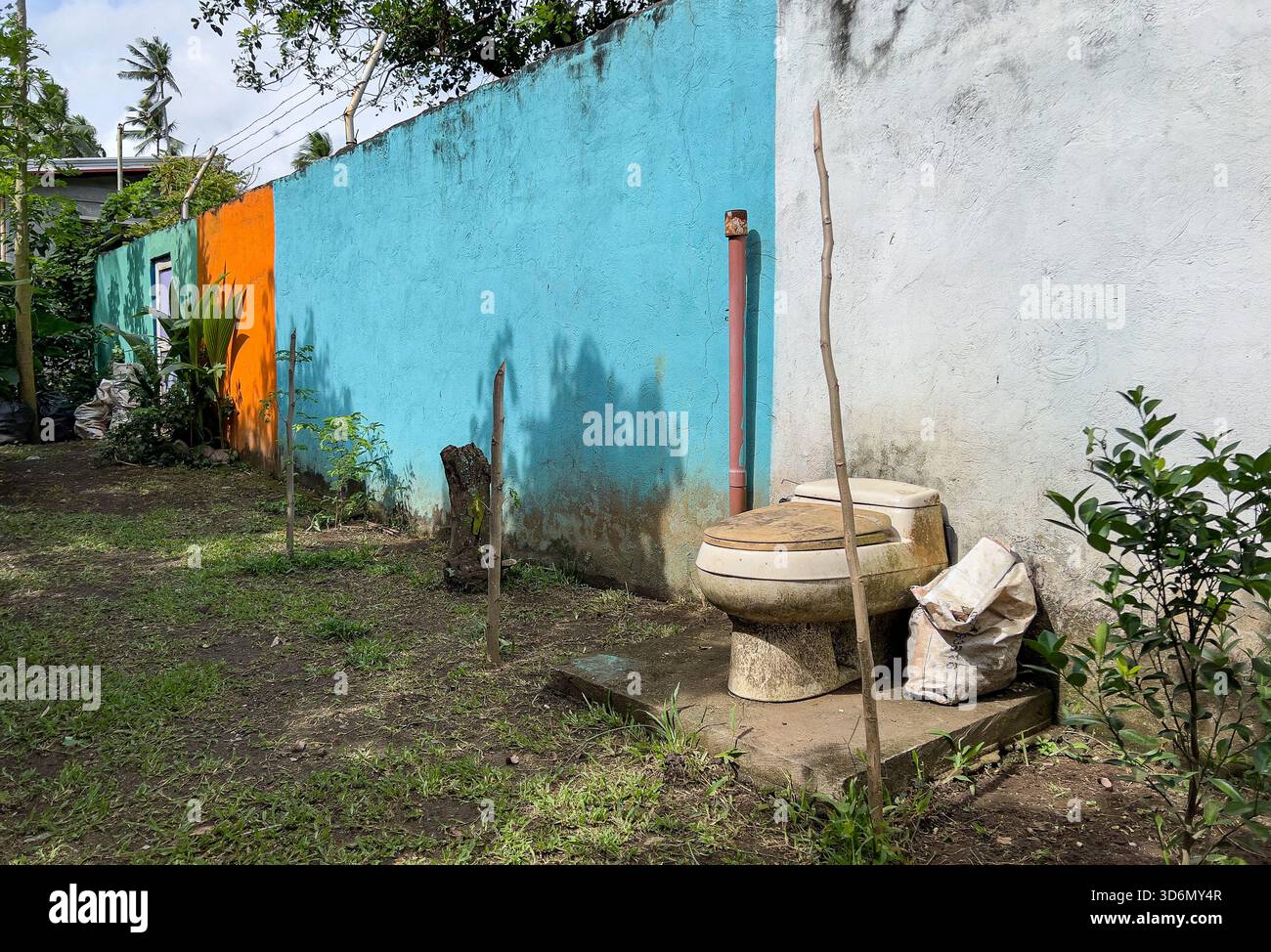 Mỹ Tho, Vietnam. Toilettes extérieures ouvertes dans un terrain partagé par plusieurs habitations. - Image de stock capturée avec un smartphone