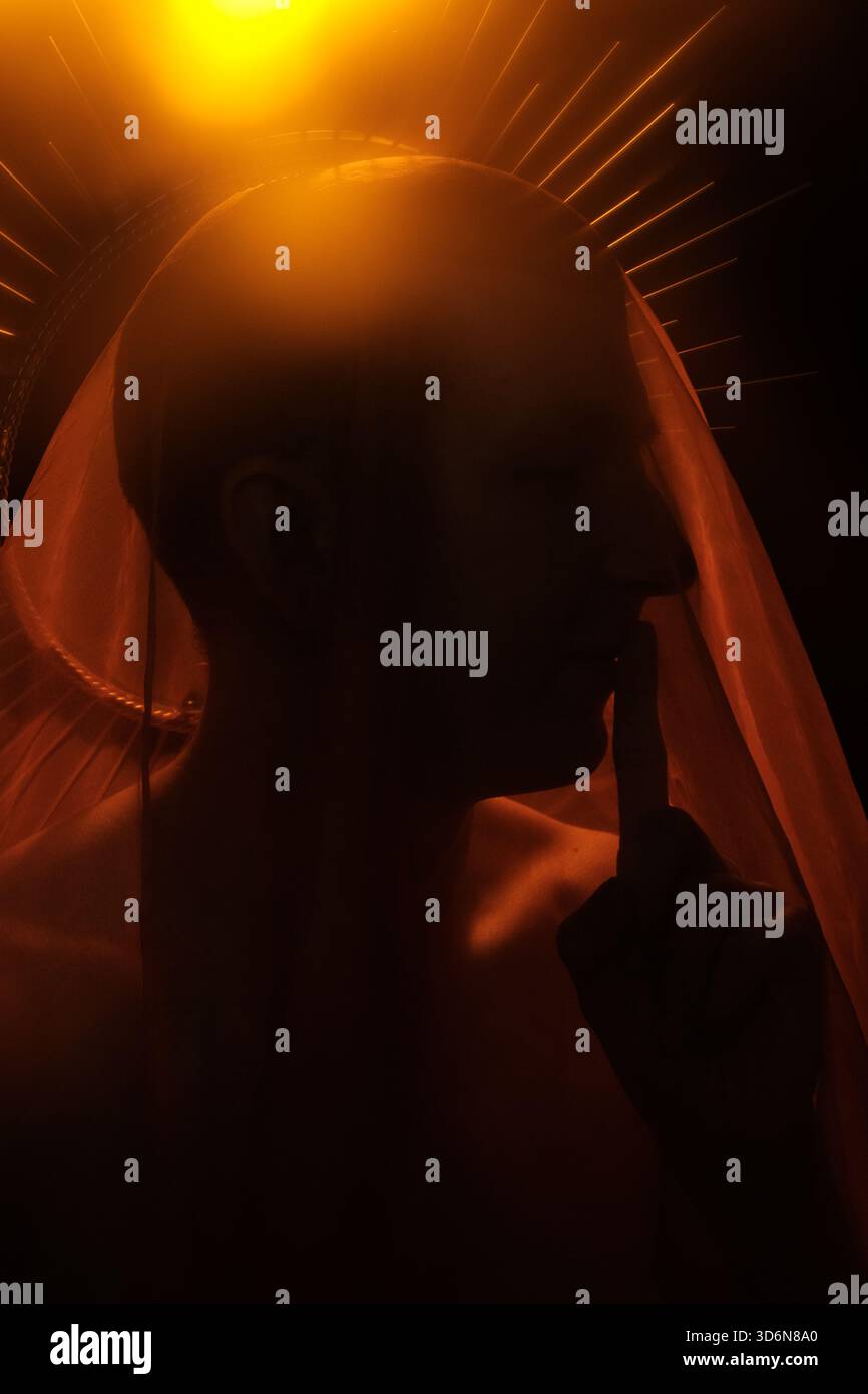 Geste silencieux dans un éclairage dramatique avec effet de voile doux Banque D'Images