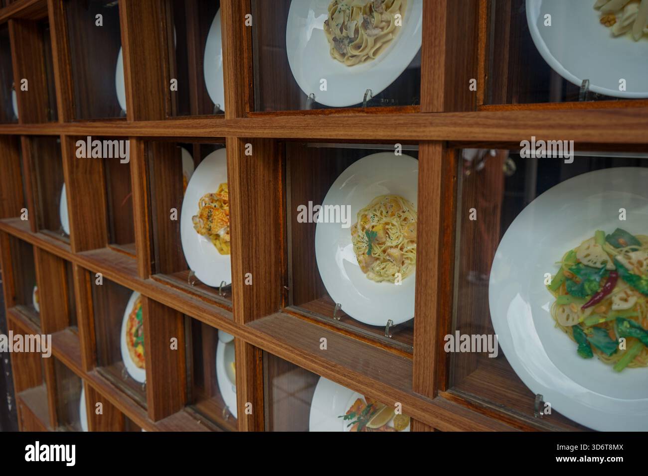 Vue rapprochée de modèles alimentaires japonais, appelés shokuhin sampuru, dans une vitrine devant un restaurant à Nara, au Japon, montrant différents plats de pâtes Banque D'Images