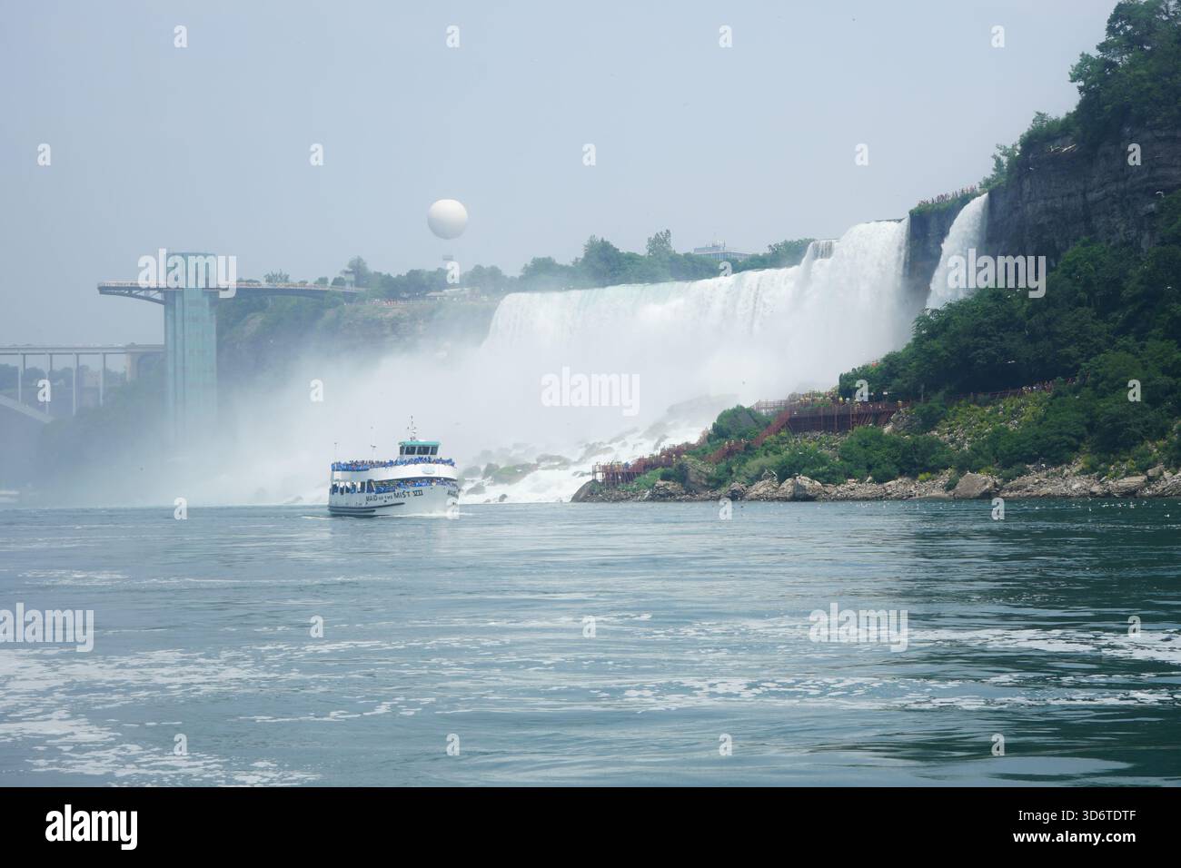 Le bateau de visite Maid of the Mist passe par les chutes américaines sur la rivière Niagara avec la tour d'observation des chutes du Niagara à Niagara Falls, Ontario, Canada Banque D'Images