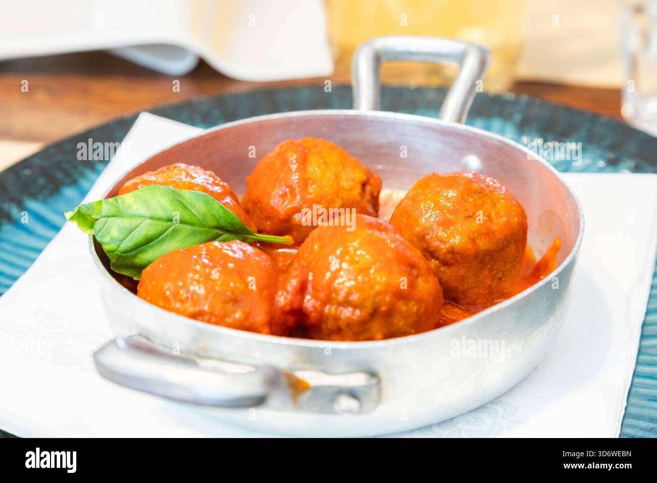 Boulettes de viande traditionnelles servies avec une feuille de basilic et une sauce tomate. Restaurant italien - nommé Osteria - à Turin, au nord de l'Italie. Banque D'Images