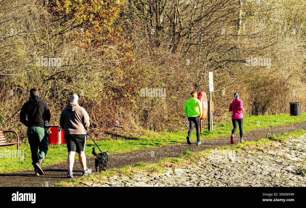 Dundee, Tayside, Écosse, Royaume-Uni. 22 novembre 2025. Météo britannique : les habitants apprécient le soleil éclatant de la fin de l'automne au Dundee Clatto Country Park, avec des eaux calmes reflétant les bois saisonniers. Crédit : Dundee Photographics/Alamy Live News Banque D'Images