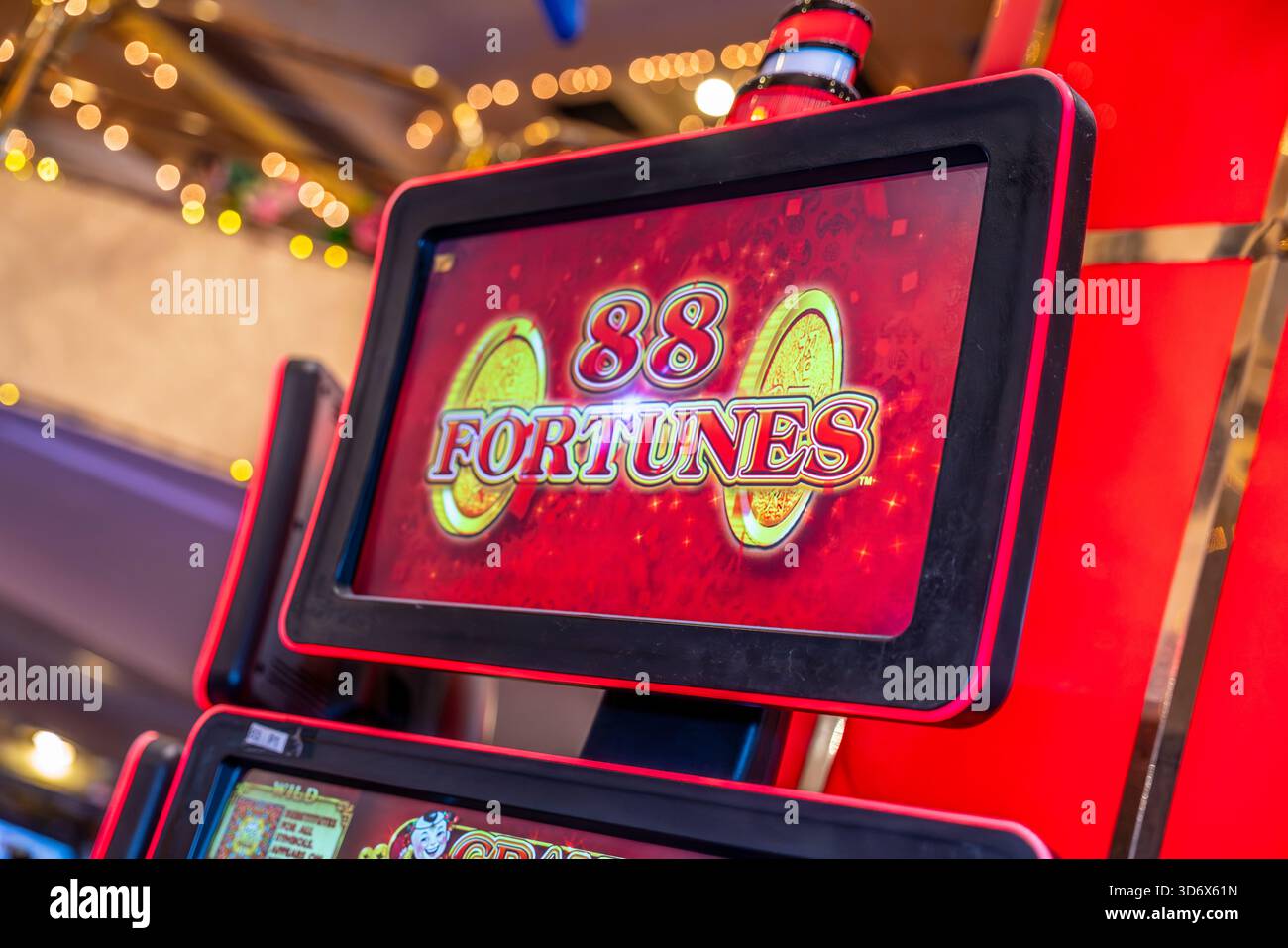 Gros plan d'un écran de machine à sous fortunes 88 avec des graphiques rouges vifs, des pièces d'or, des détails illuminés et une atmosphère de casino dynamique. Banque D'Images