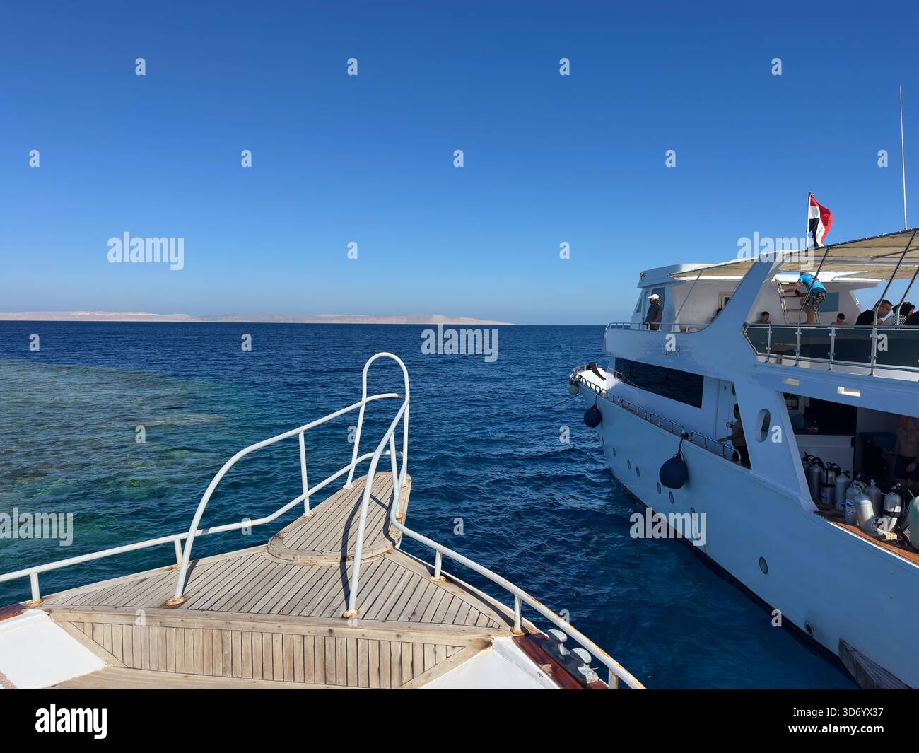 Pont avant de bateau de plongée à côté d'un bateau de croisière amarré avec drapeau égyptien, mer Rouge, Egypte Banque D'Images