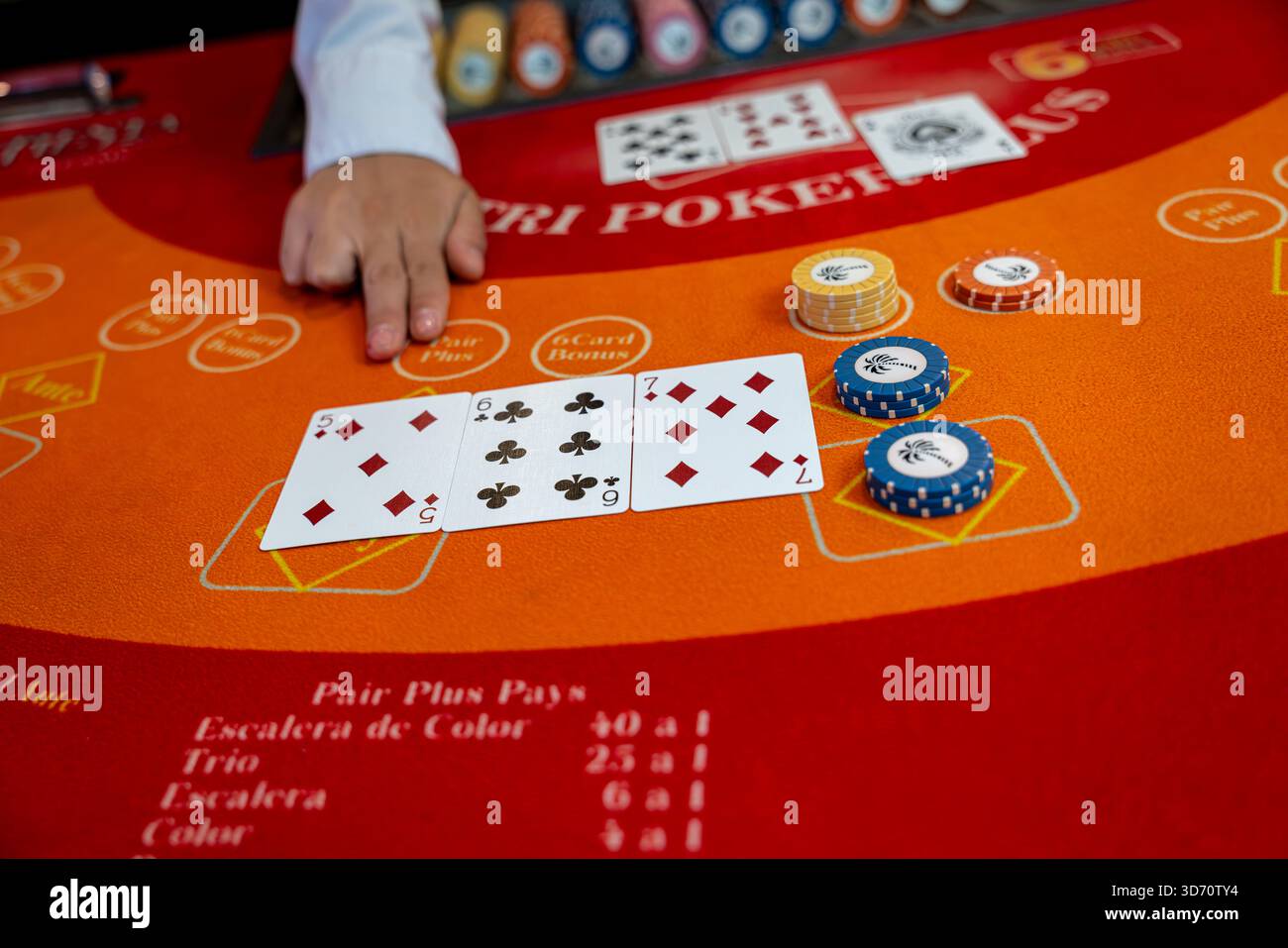 Main de croupier pointant sur des cartes sur une table de poker des Caraïbes avec des jetons de casino, concept de jeu, Paris, stratégie, risque et divertissement de casino. Banque D'Images