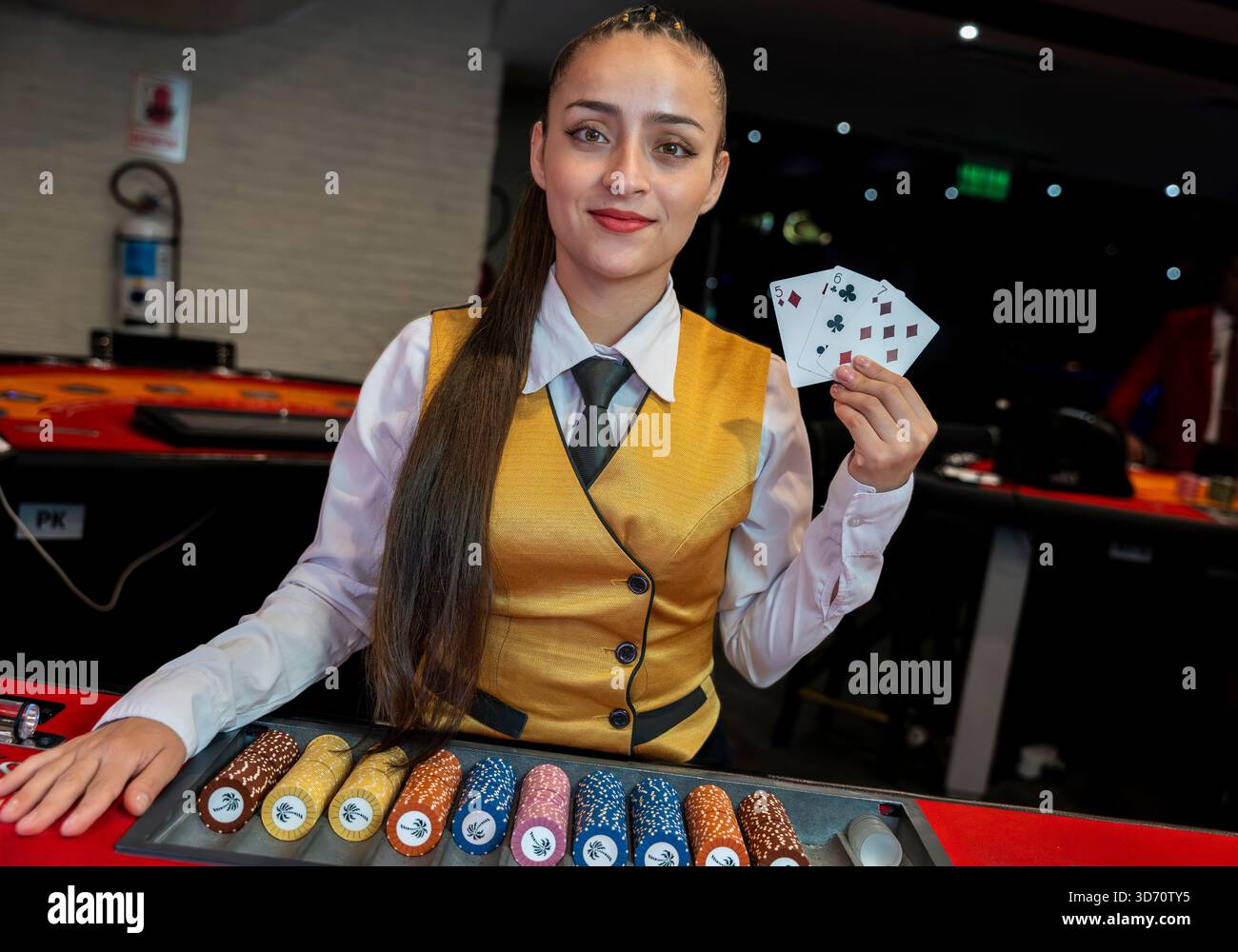 Croupier de casino féminin tenant des cartes à jouer derrière la table de poker, service professionnel, art conceptuel intérieur de scène de salle de jeux de luxe Banque D'Images
