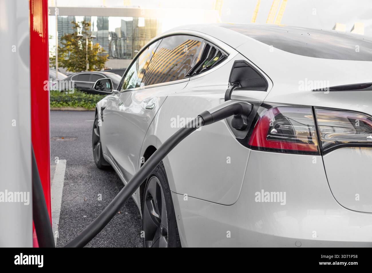 Voiture électrique à la station de charge rapide, EV blanc branché. Londres, Royaume-Uni, 14 octobre 2023 Banque D'Images