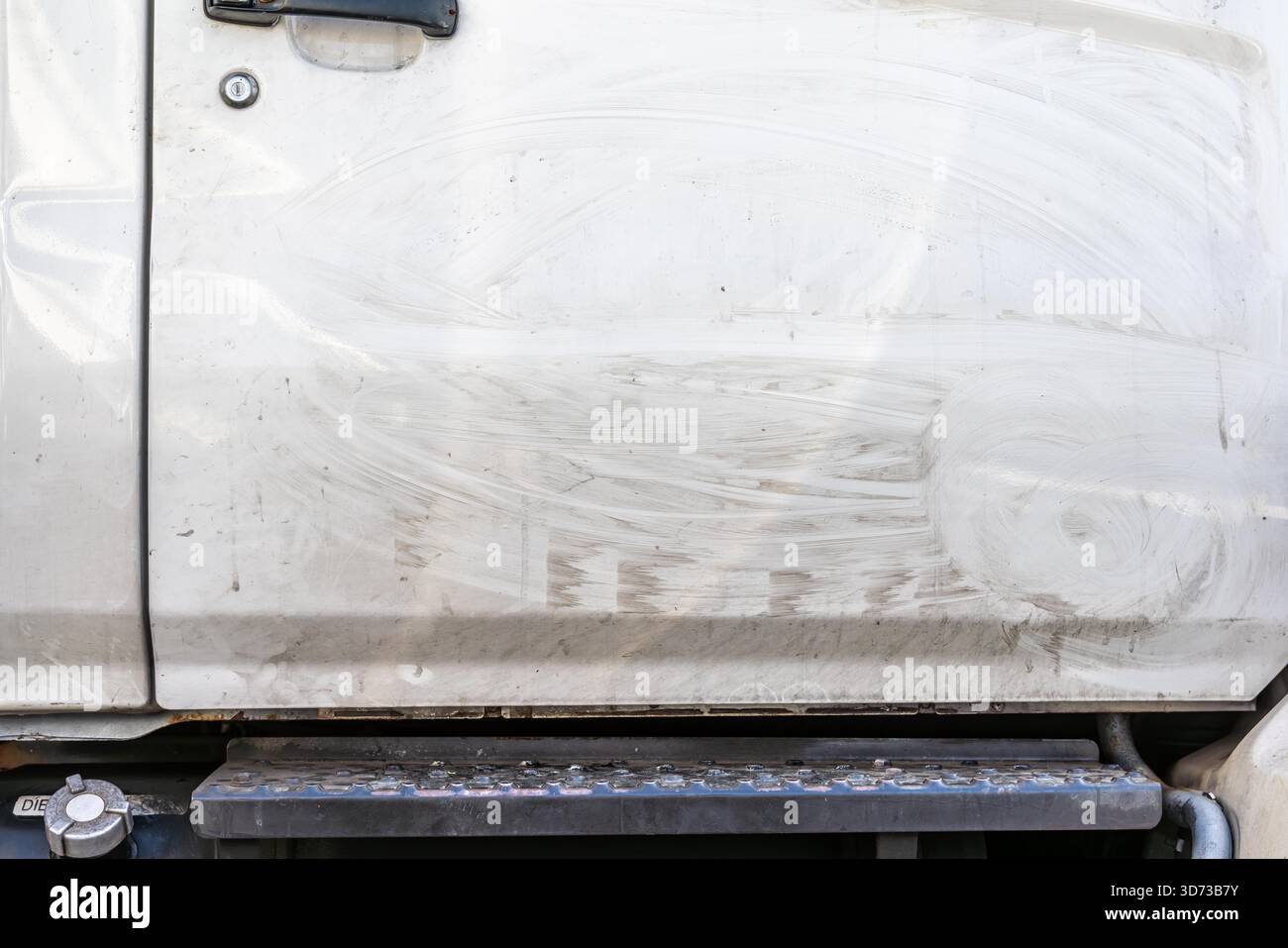 marques aléatoires dans la saleté séchée sur une porte d'un camion blanc Banque D'Images
