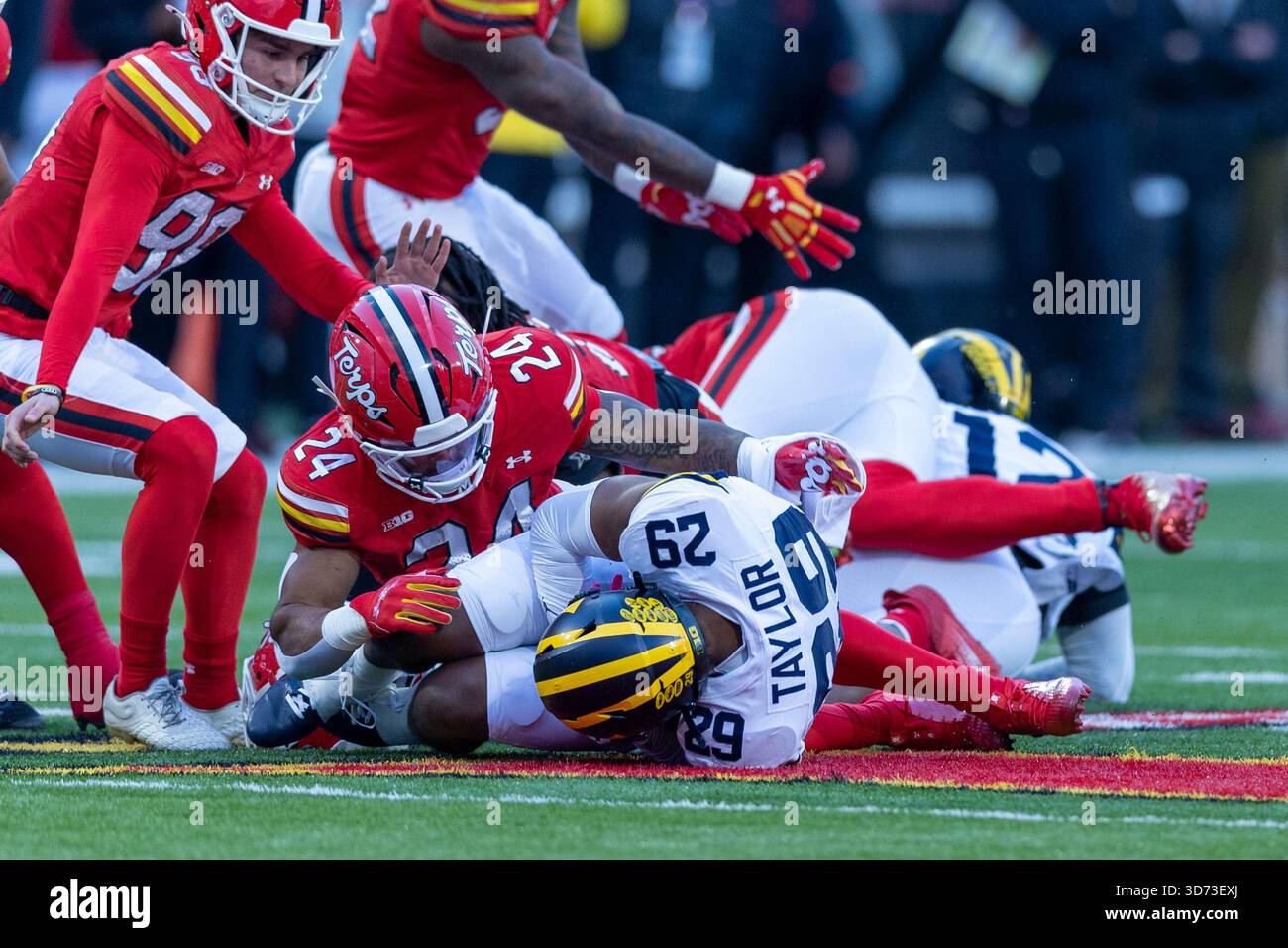 College Park, États-Unis. 22 novembre 2025. College Park, MD : le linebacker des Michigan Wolverines Chase Taylor (29) récupère un coup de pied en concourant avec les Maryland Terrapins en arrière Iverson Howard (24 ans), le kicker Ryan Capriotti (98 ans) et d'autres au cours du premier quart-temps lors d'un match de la NCAA le samedi 22 novembre 2025 au SECU Stadium. Les Wolverines battent les Terrapins 45-20. (Bob Blakley/image du sport) crédit : image du sport /Alamy Live News Banque D'Images