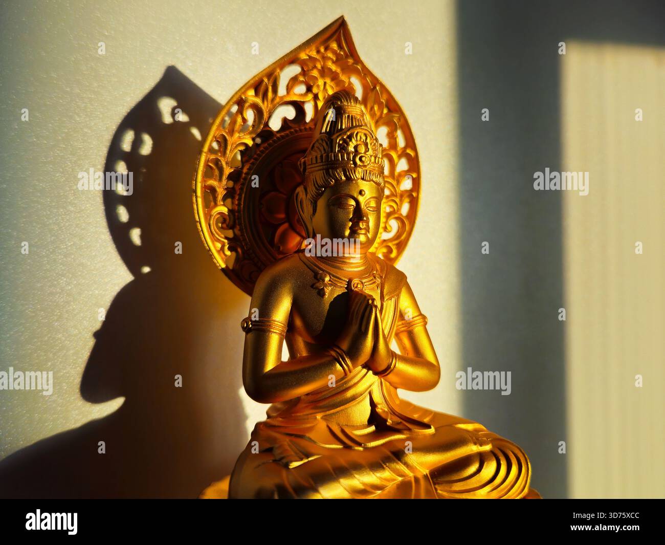 Statue bouddhiste dorée dans une lumière latérale dramatique Banque D'Images
