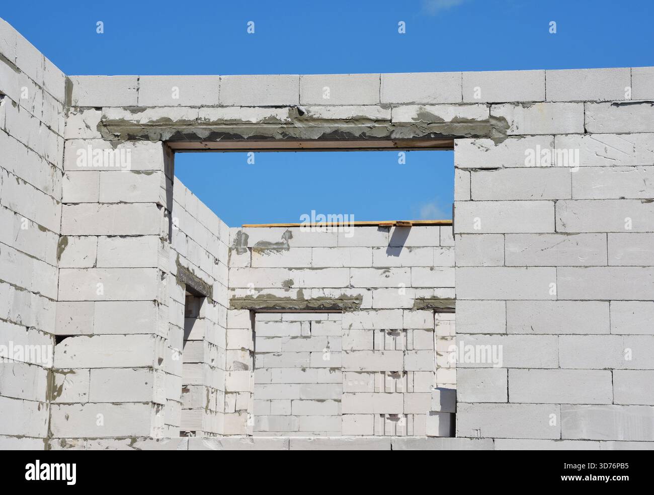Mur de construction avec fenêtres, ouvertures de porte et linteaux en métal.mur de bâtiment non fini en blocs de béton avec ouvertures de fenêtre et de porte refor Banque D'Images