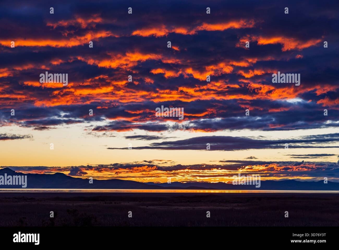 La rémanence du coucher du soleil se reflète dans les nuages au-dessus du Grand Lac Salé vu depuis le parc d'État d'Antelope Island, comté de Davis, Utah, États-Unis. Banque D'Images