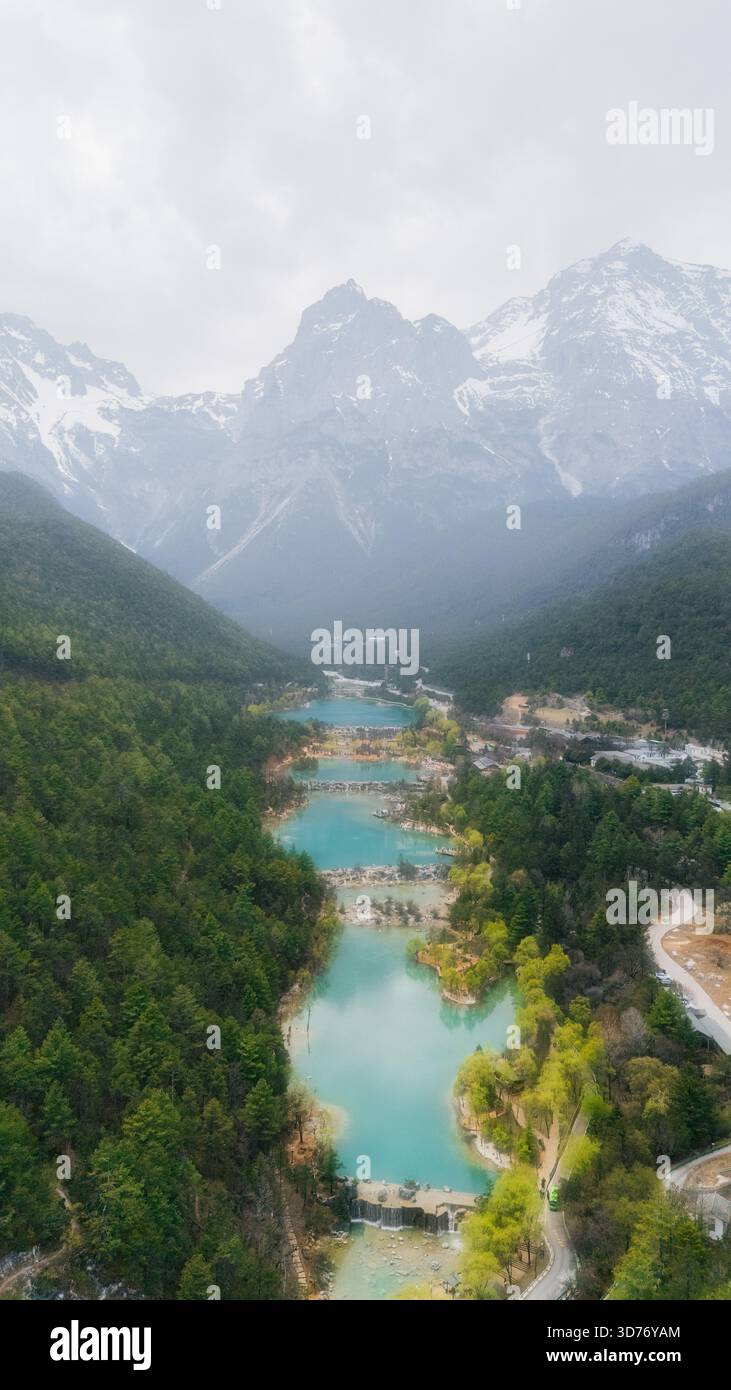 Vue aérienne sur les eaux turquoises vibrantes qui traversent la sereine Blue Moon Valley, nichée sous la montagne enneigée du Dragon de Jade, Banque D'Images