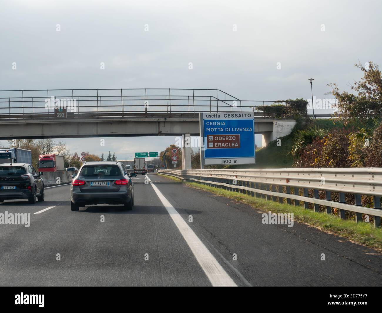 Frioul, Italie 21 novembre 2025 scène de l'autoroute A4 en Italie avec un panneau de sortie pour diverses villes, montrant des voitures et des camions voyageant près d'une traverse de pont Banque D'Images
