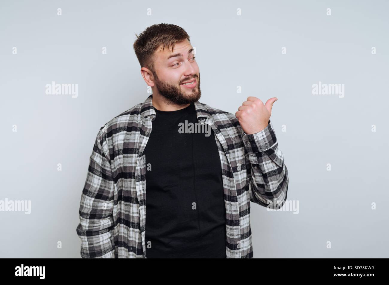 portrait d'un jeune homme sympathique présentant un geste du pouce vers le haut, rayonnant de l'énergie positive et de la confiance sur fond blanc Banque D'Images