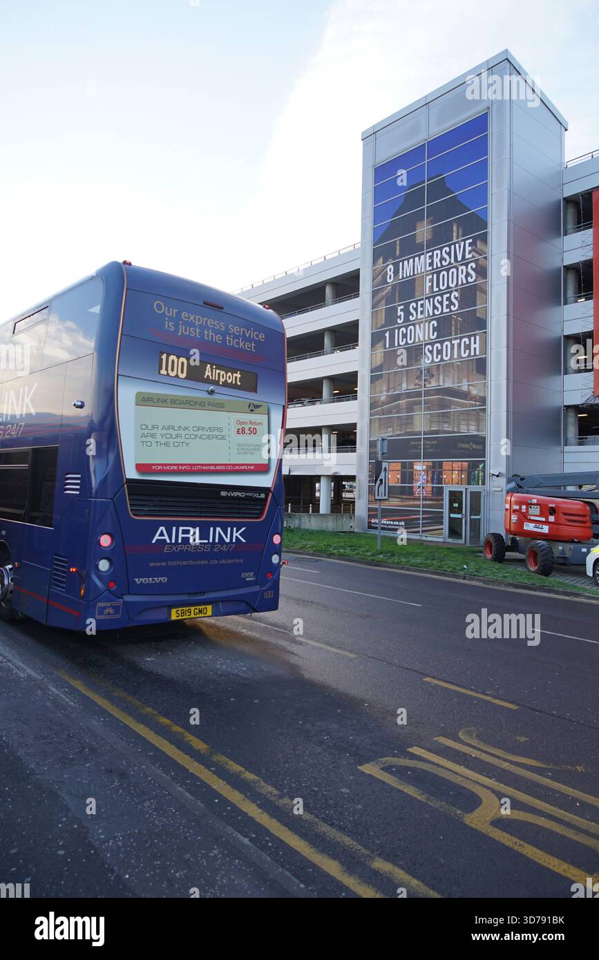 Airlink 100 bus de l'aéroport à l'extérieur de l'aéroport d'Édimbourg avec une annonce Johnnie Walker Experience en arrière-plan.Édimbourg, Écosse Banque D'Images