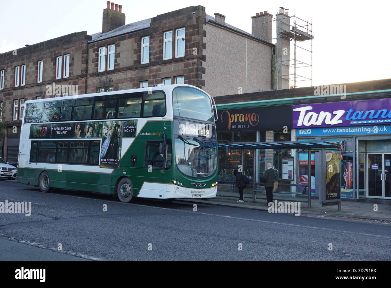 Bus Lothian à impériale qui prend des passagers à un arrêt de bus de banlieue d'Édimbourg par un matin froid. Édimbourg, Écosse Banque D'Images