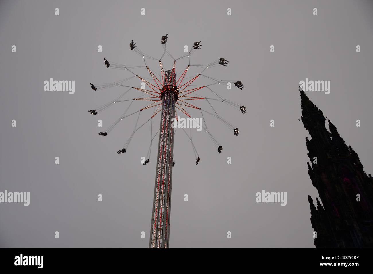 Tour de foire à balancement élevé tournant au-dessus d'Édimbourg avec le Scott Monument silhouetté à côté d'it.Edinburgh, Écosse Banque D'Images