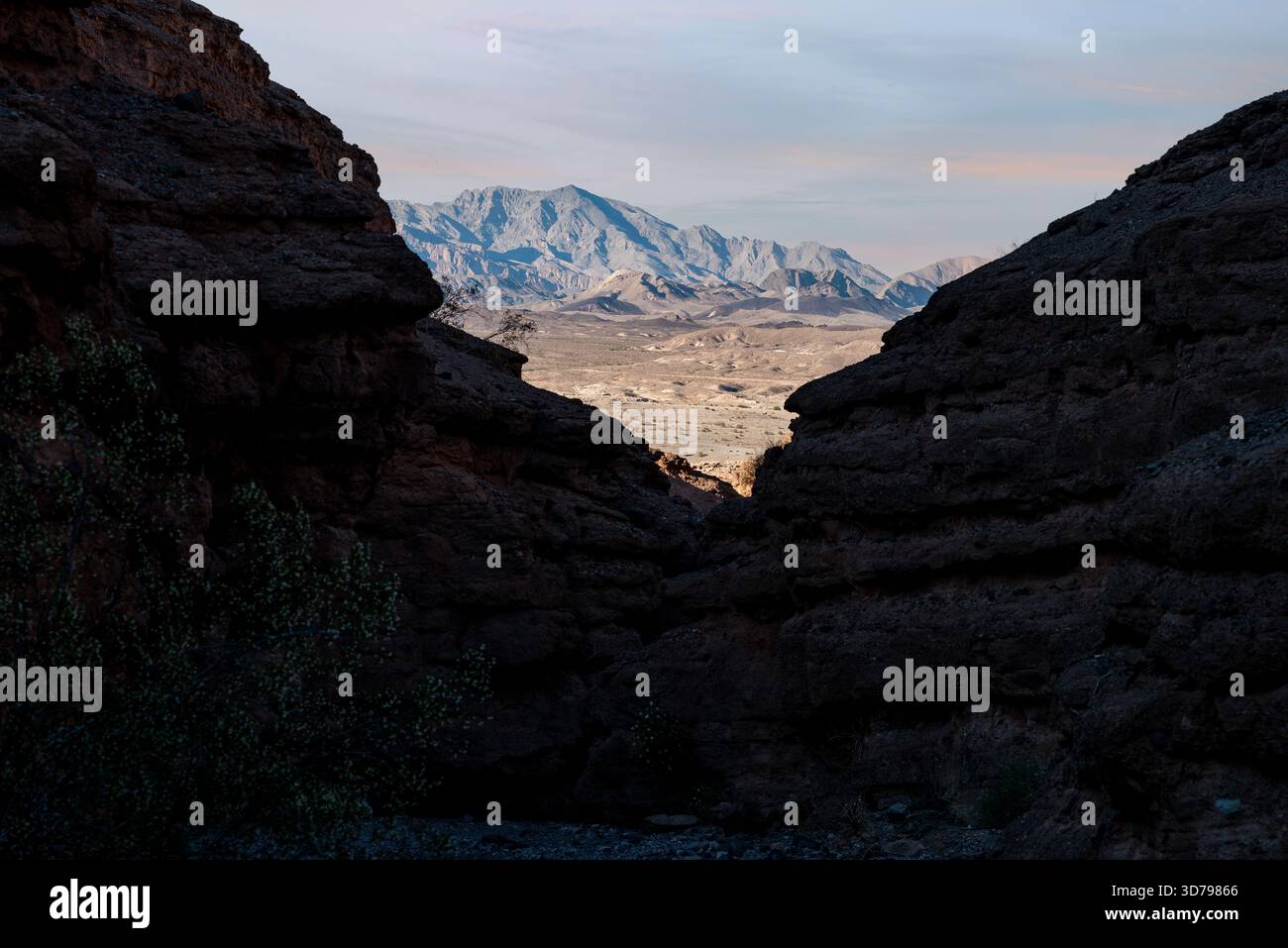 Cette image a été prise à Lake Mead National Recreation Area dans le Nevada. Il présente des montagnes au loin, éclairées par la lumière chaude du coucher du soleil. Banque D'Images