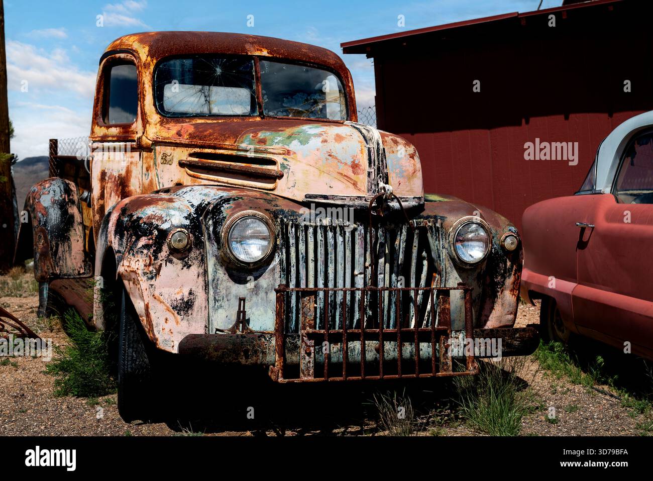 Cette camionnette antique abandonnée, peinte en orange délavé, se trouve dans une junkyard du désert le long de l'historique route 66 des États-Unis en Arizona. Banque D'Images