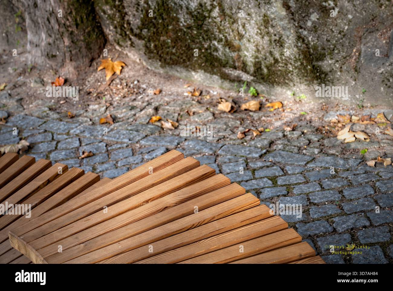 Vue abstraite d'un banc en bois et d'une passerelle pavée Banque D'Images