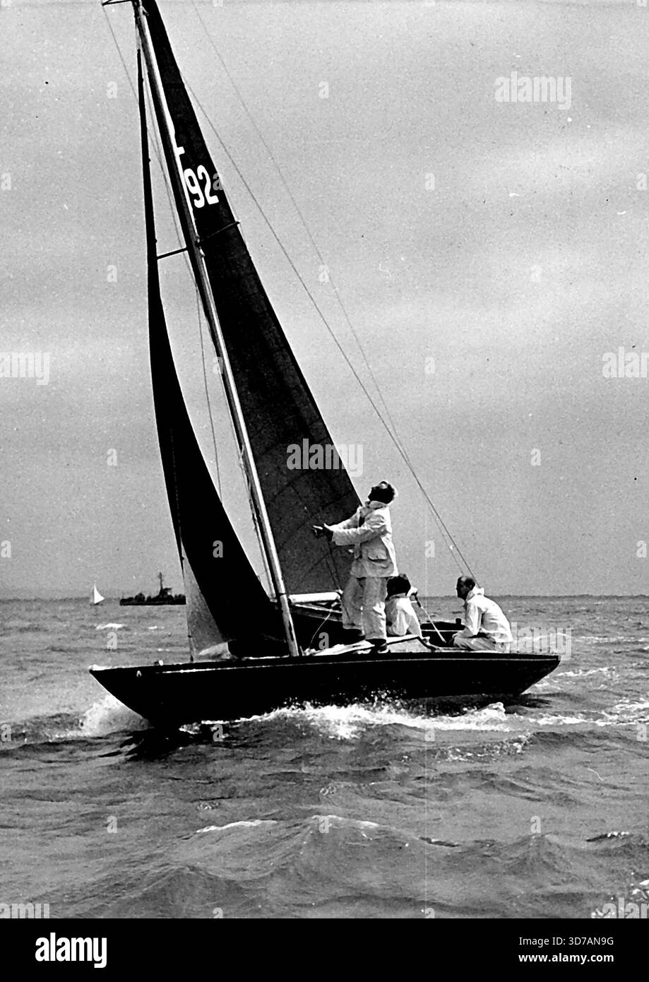 Duc d'Édimbourg au tiller de la Bluebottle.le duc d'Édimbourg a pris sa retraite de la course de classe Dragon à Cowes Regatta hier après dix minutes. Bluebottle, le yacht Be possède conjointement avec la Reine, a été endommagé dans une collision, on pense, avec un moteur de lancement. Son séjour avant a été emporté et il est retourné au port avec sa voile principale à moitié abaissée. 8 mai 1953. Banque D'Images