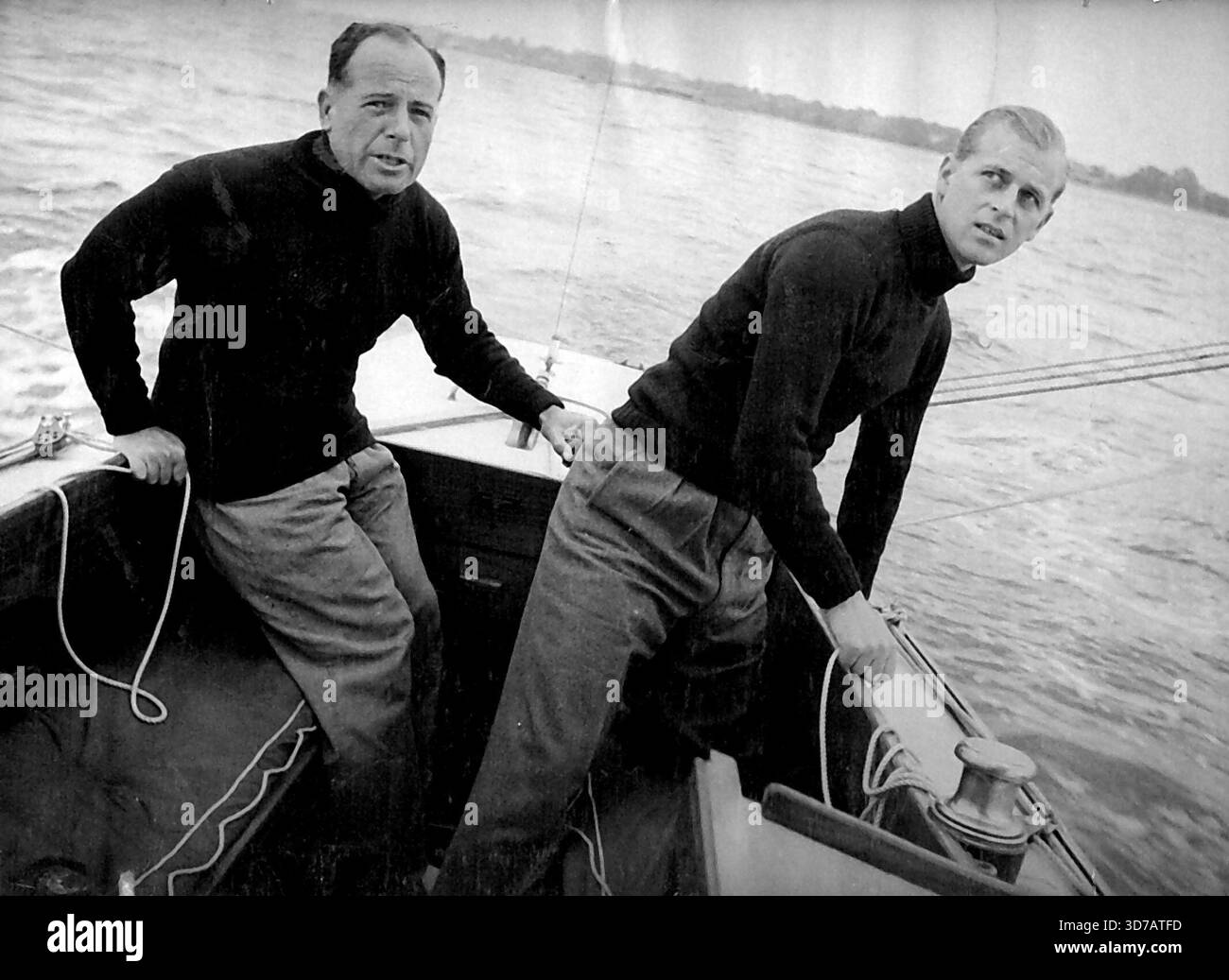 Le duc d'Édimbourg à bord de la 'Bluebottle' - couper le spinnaker tout en courant devant le vent le duc d'Édimbourg avec le lieutenant-commander Michael Crochton, le timonier du yacht. Le 'Bluebottle', un yacht du verre Dragon (app. L8ft. Long) a été présenté à leurs Altesses Royales la Princesse Elizabeth et le Duc d'Édimbourg par le Island Sailing Club. Le Duke a disputé sa première course sur le yacht quand il est entré dans la « Bluebottle » lors d'un récent événement de yachting à Cowes. Dans l'équipage de trois du yacht, le duc agissait comme troisième main. Le premier jour, 'Bluebottle' est arrivé troisième mais disqua Banque D'Images