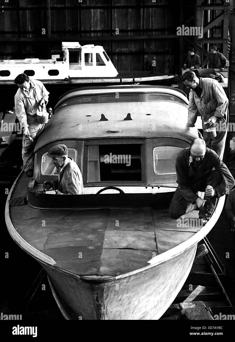 La barge royale de Britannia est prête pour l'examen du couronnement - artisans travaillant sur la barge royale à **** . La barge royale pour le nouveau yacht royal Britannia (lancé récemment par le Queen on Clydeside) est en cours de préparation à Portsmouth Dockyard. La barge, construite par une entreprise de Portsmouth en 1938, est dépouillée, repeinte et dorée par une bande d'artisans qualifiés dans le grand hangar à bateaux du chantier naval. Avant que la barge ne « rejoigne » le Britannia, il sera présent lors du H.M.S. surprise (le navire d'expédition qui sera utilisé par la Reine et le Duc d'Édimbourg) lors de la Caronation Naval Rev Banque D'Images