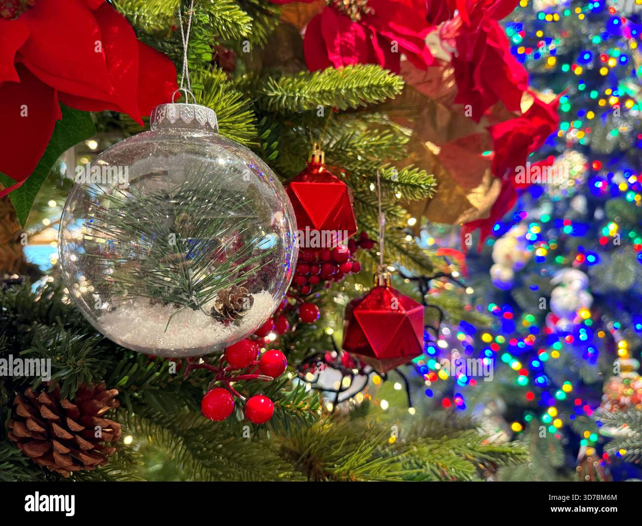 Arbre de Noël avec boule transparente, fleurs rouges, guirlande Banque D'Images