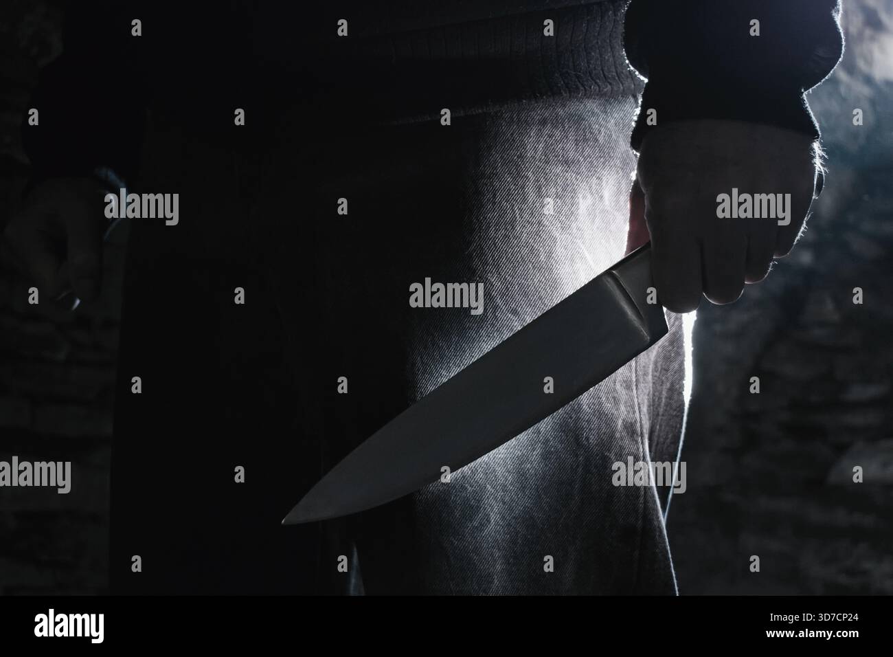 Photo sombre d'un homme tenant un gros couteau, concept de crime. Banque D'Images